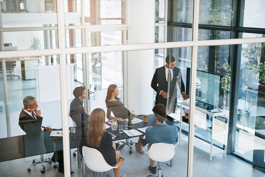 Reunião de equipa em ambiente corporativo, representando aconselhamento financeiro e intermediação de crédito especializada.
