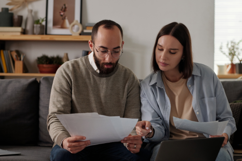 Casal em casa a analisar documentos e orçamento antes de comprar casa